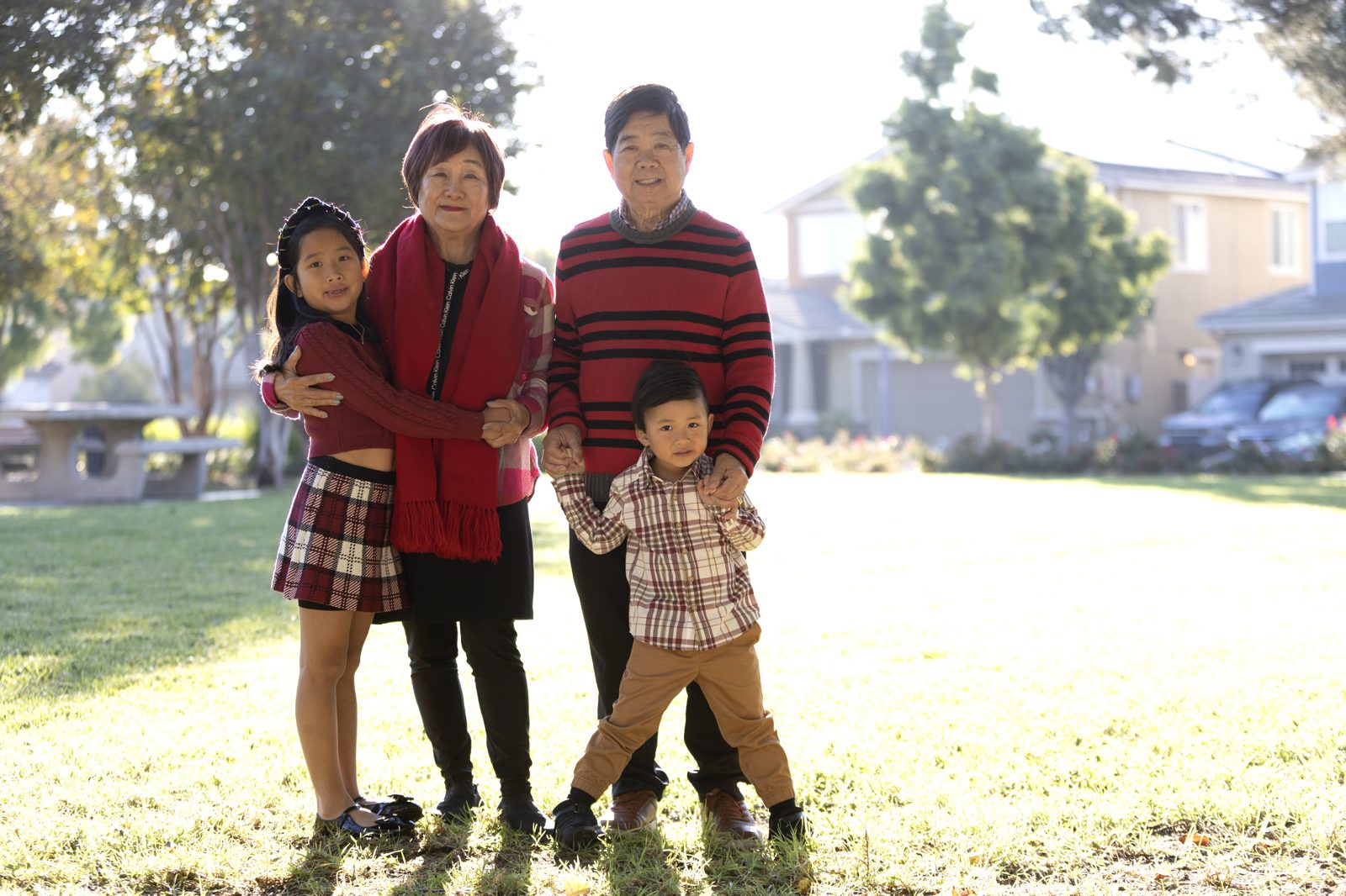 Three generations of a family together outdoors — grandparents with their grandchildren